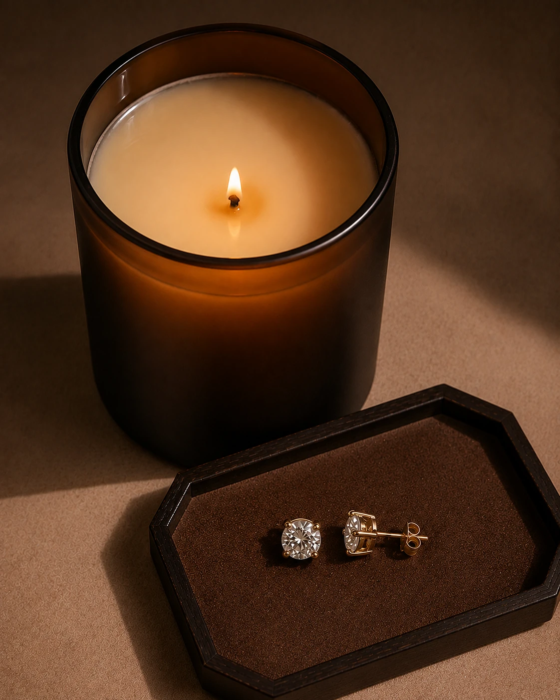Luxe Reveal candle with melted wax beside a pair of revealed jewelry earrings